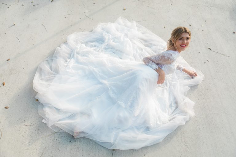 Taylor posing in custom lace wedding dress by Angela Kim