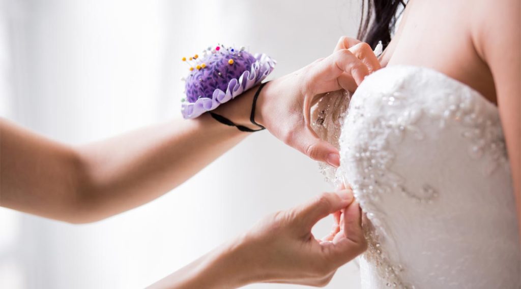 Angela Kim fitting a new bride with a custom wedding gown
