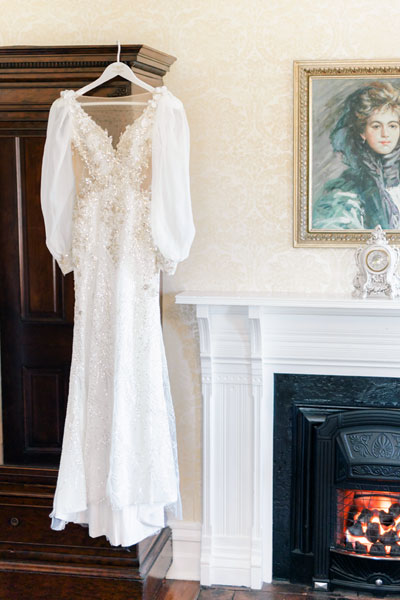 Wedding dress hanging by the fireplace