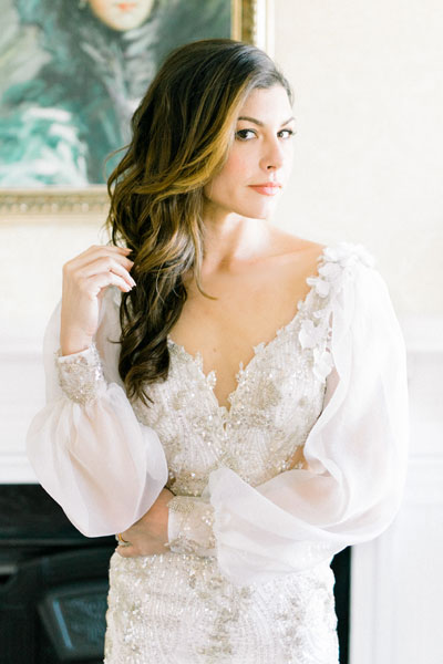 Lauren posing for a bridal portrait in her custom wedding dress from Angela kim Couture