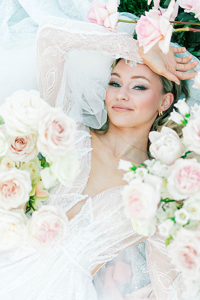 Natalie posing in a bed of wedding flowers