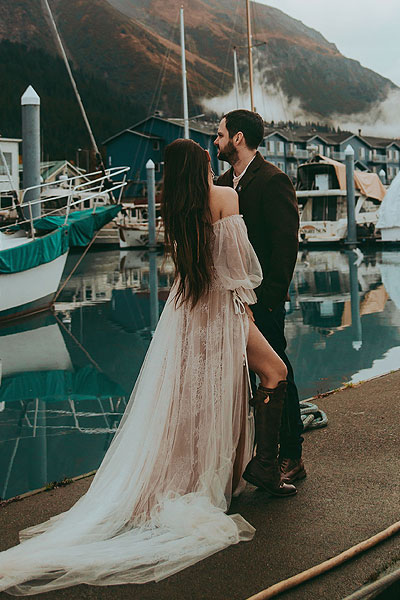 Caroline posing in her wedding gown on a dock