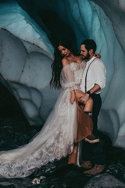 Caroline poising in her bridal gown in an ice cave
