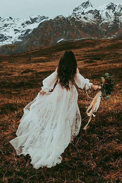 Caroline running up a mountain in her wedding dress