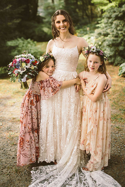 Kate posing with her flower girls in her boho wedding dress