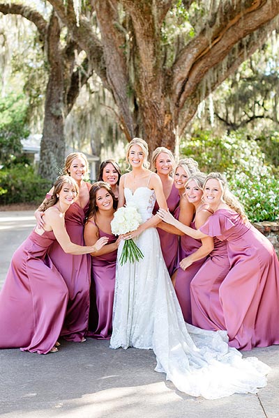 Erin posing in her wedding gown with bridesmaids