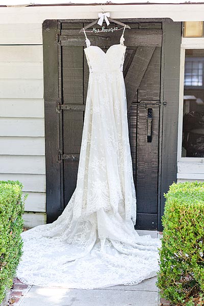 Erin's wedding dress hanging on a door