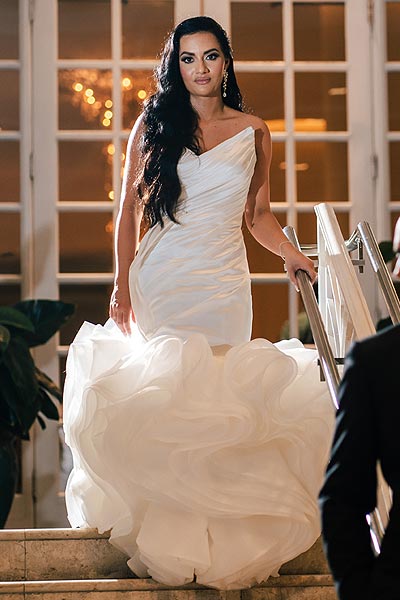 Chelsea descending some stairs in her wedding gown
