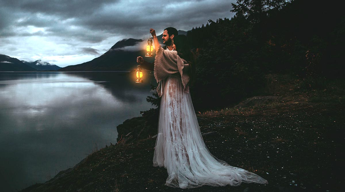 Caroline wearing her custom wedding dress and holding a lantern