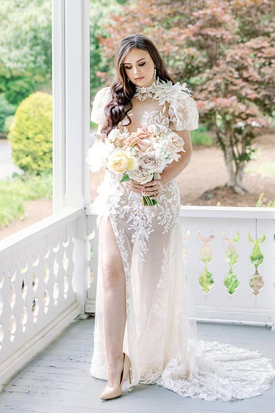 Masha posing on a porch in her custom wedding dress