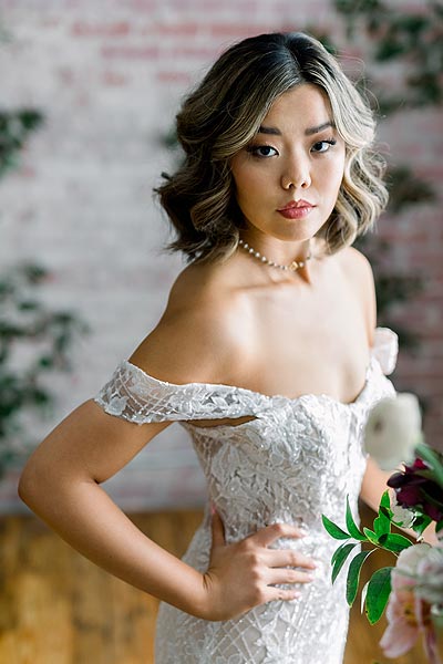 Hannah wearing a wedding dress with off-the-shoulder sleeves