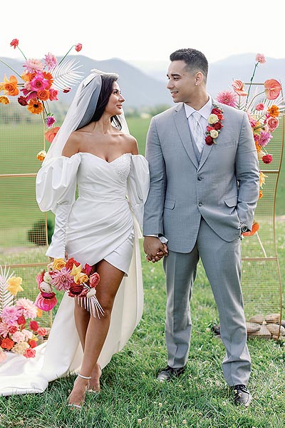 Veronica and Nick walking among the flowers on their Big Day