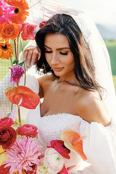 Veronica posing among the flowers in her custom bridal dress