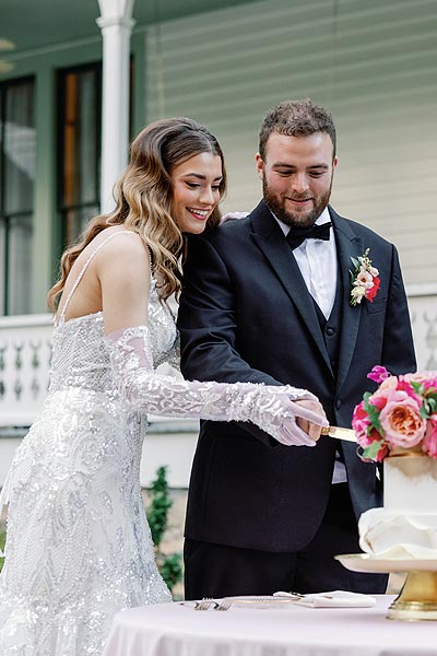 Kyra and will cutting their wedding cake