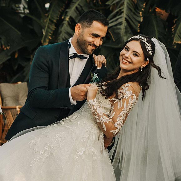 Masha in her custom wedding gown posing with her groom