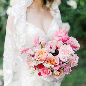Kyra holding a bridal bouquet in her custom wedding dress.
