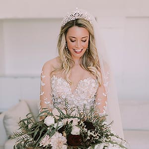 Breigh smiling and holding her wedding bouquet.