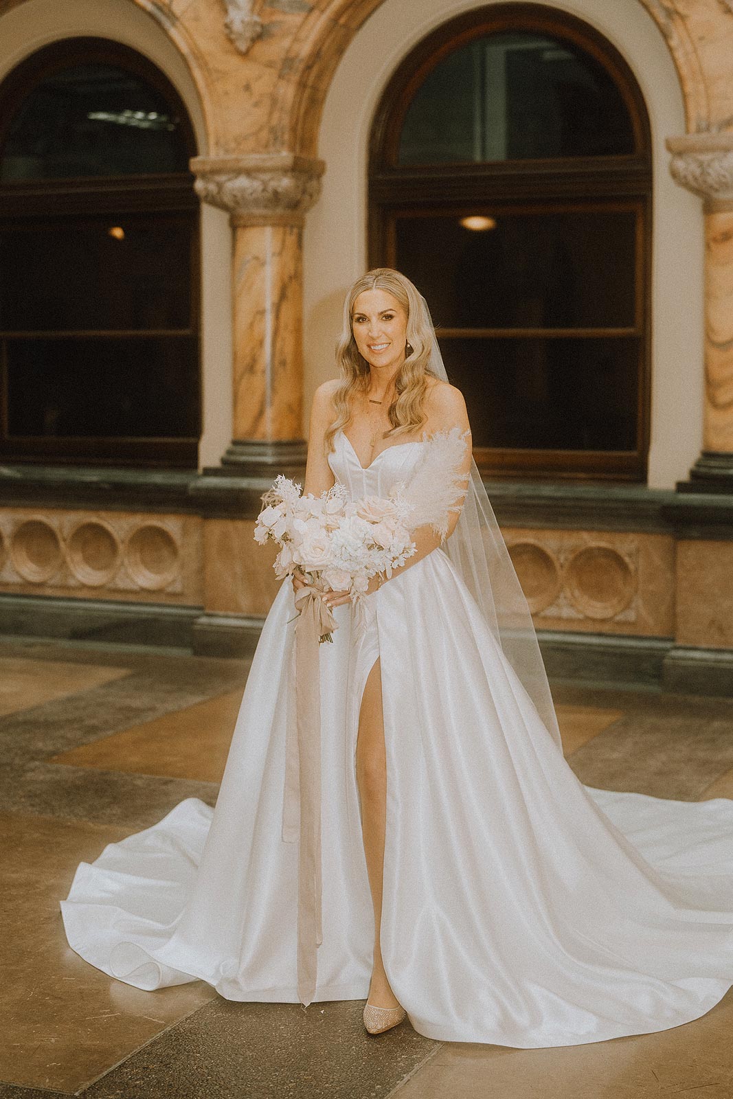 Elizabeth posing in her custom wedding dress with a high leg baring slit