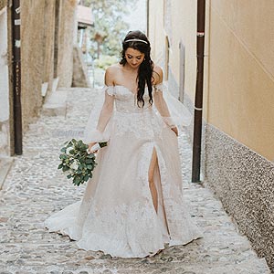 Morgan in her custom wedding gown walking up an alley in Italy.