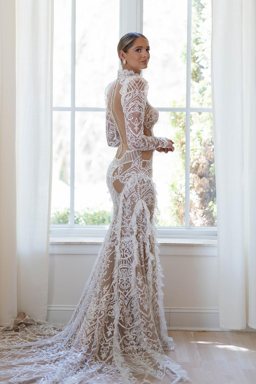 Side view of Peyton posing in her custom lace bridal gown.